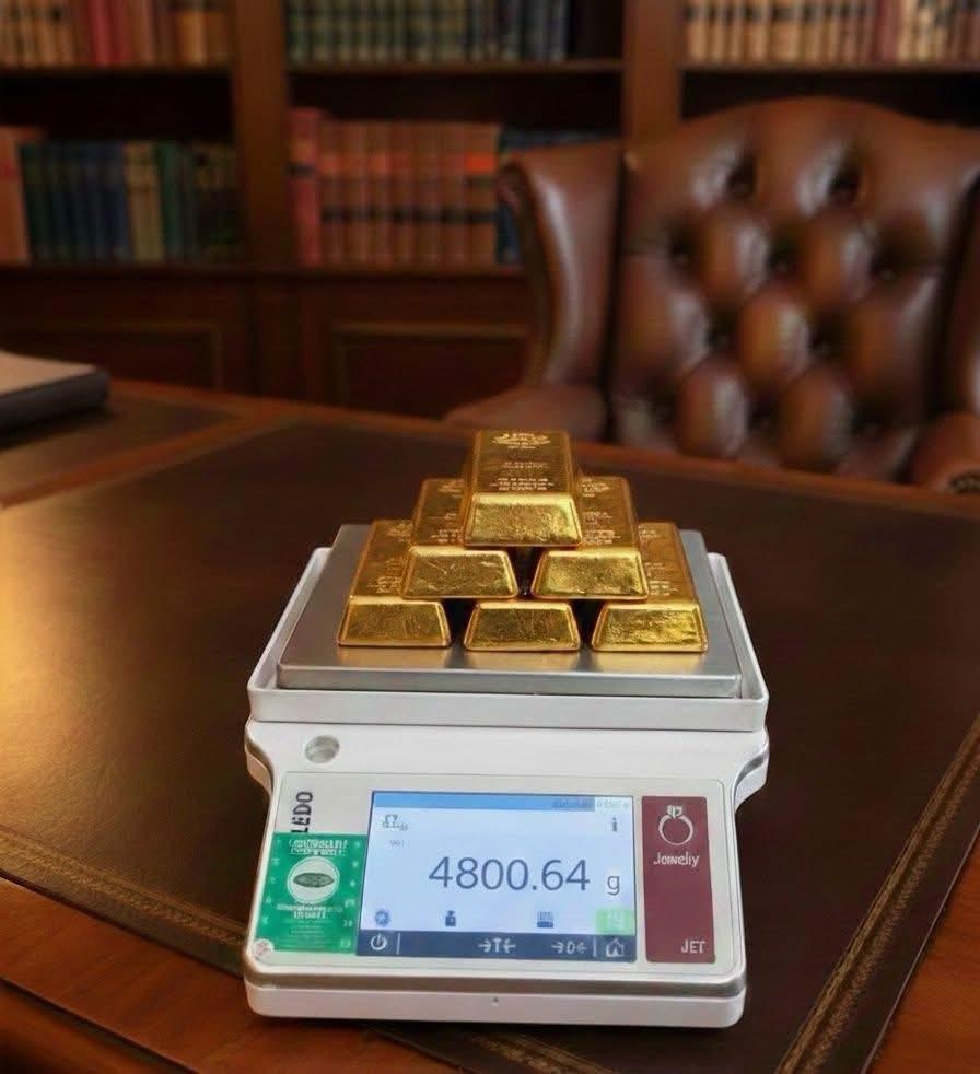 Professional gold bars being precisely weighed on calibrated scale demonstrating authentic gold handling expertise and quality verification process